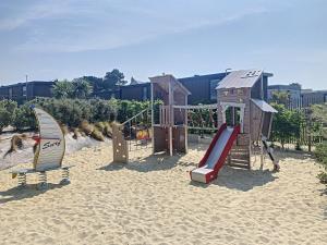 einen Spielplatz mit Spielgeräten im Sand in der Unterkunft Mobil-Home Jullouville, 4 pièces, 6 personnes - FR-1-361A-74 in Jullouville-les-Pins