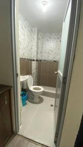 a small bathroom with a toilet and a sink at Apto. a una cuadra del Terminal in Quito +10 photos