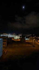a view of a city at night with a moon at Apto. a una cuadra del Terminal in Quito