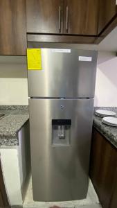 a stainless steel refrigerator in a kitchen at Apto. a una cuadra del Terminal in Quito