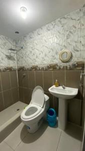 a bathroom with a toilet and a sink at Apto. a una cuadra del Terminal in Quito