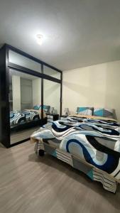 a bedroom with a bed and a large mirror at Apto. a una cuadra del Terminal in Quito