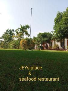 a field of green grass with the words keys place and seafood restaurant at JEYs Place in Nilaveli