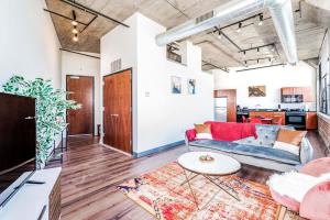 a living room with a couch and a table at Architect's Stunning loft by CozySuites in Saint Louis