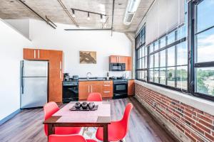 eine Küche mit einem Tisch, Stühlen und einer Ziegelwand in der Unterkunft Architect's Stunning loft by CozySuites in Saint Louis