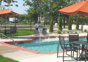 a pool with chairs and a grill and an umbrella at Architect's Stunning loft by CozySuites in Saint Louis