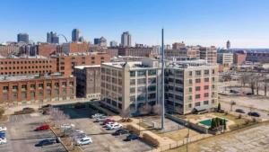 a large white building with a parking lot in a city at Architect's Stunning loft by CozySuites in Saint Louis