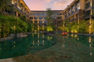 an exterior view of a building with a swimming pool at Brand New Apartment at Nusa Dua Bali in Nusa Dua