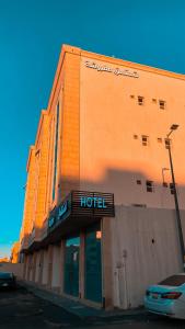 un bâtiment d'hôtel avec un panneau d'hôtel devant lui dans l'établissement هوتيل القصيم 2 للشقق الفندقية, à Buraydah