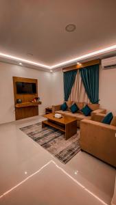 - un salon avec un canapé et une télévision dans l'établissement هوتيل القصيم 2 للشقق الفندقية, à Buraydah