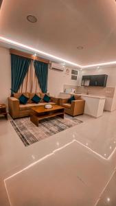 a living room with couches and a table at هوتيل القصيم 2 للشقق الفندقية in Buraydah