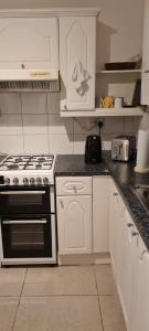 a kitchen with white cabinets and a stove top oven at Scotland Street, Newton Heath in Manchester