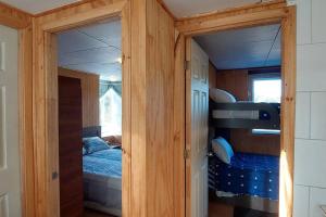 Cabaña Zorro Chilote في دالكاوي: غرفة صغيرة مع سرير بطابقين في منزل