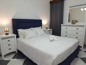 - une chambre avec un grand lit blanc et 2 tables de chevet dans l'établissement Apartment in Biscoitos Terceira, à Biscoitos