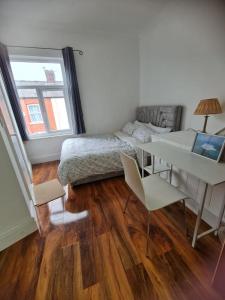 Schlafzimmer mit einem Bett, einem Schreibtisch und einem Tisch in der Unterkunft Scotland Street, Newton Heath in Manchester