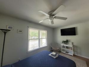 una camera con letto blu e ventilatore a soffitto di The Yellow Bungalow a Savannah