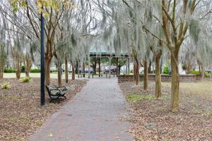 un parque con banco, árboles y cenador en The Yellow Bungalow, en Savannah