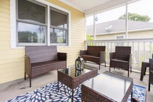 veranda con sedie e tavolo in vetro di The Yellow Bungalow a Savannah
