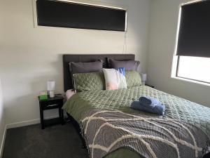 a bedroom with a bed with a blue towel on it at Place for a Holiday in Papamoa