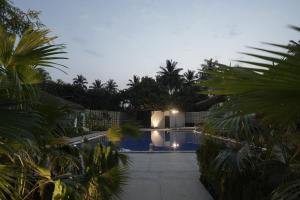 a view of a swimming pool at night with palm trees at Vanya in Bangalore