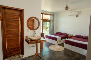 a bedroom with two beds and a mirror and a table at Hotel Sanmara in La Sabrosa