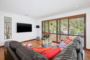 デイルスフォードにあるSerenity-2 living areas-decks-fireplace-Netflixのソファと薄型テレビのあるリビングルーム