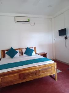 - une chambre avec un grand lit et des oreillers bleus dans l'établissement ROCK VIEW RELAX Inn, à Sigirîya