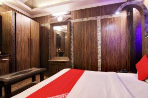 a bedroom with wooden walls and a bed and a mirror at OYO AIRPORT PITTORS QUE DELHI in New Delhi