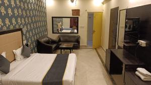 1 dormitorio con 1 cama, 1 silla y TV en Hotel Amrit Resort en Alwar