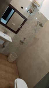 ein Badezimmer mit einem WC, einem Waschbecken und einem Spiegel in der Unterkunft Hotel Amrit Resort in Alwar