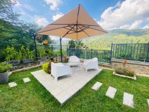 a patio with two chairs and an umbrella at Dream Hills Villa, Nillambe Kandy in Kandy