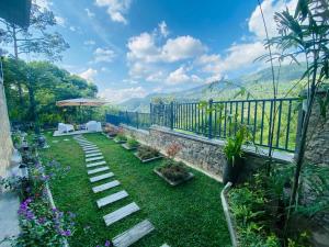 a garden with a stone fence and grass and flowers at Dream Hills Villa, Nillambe Kandy in Kandy