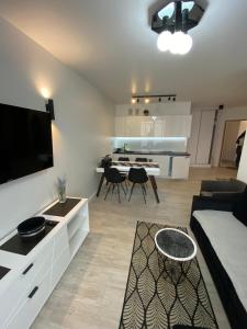 un soggiorno con un divano e un tavolo con una televisione di BALTIC SUN a Sztutowo Altre 9 foto