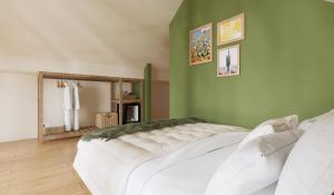 zieloną sypialnię z dużym białym łóżkiem. w obiekcie Chloe Homestay w mieście Da Lat