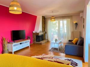 ein Wohnzimmer mit einem gelben Sofa und einer rosa Wand in der Unterkunft 花园露台 温馨舒适的高层全景公寓 免费公共停车位 距机场15分钟 设有儿童主题亲子房 in Athen
