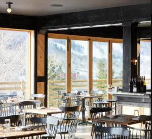 un comedor con mesas, sillas y ventanas en SPECTACULAR CATSKILLS 4 BEDROOM VACATION OASIS- Gorgeous Hunter Mountain Views!, en Hunter
