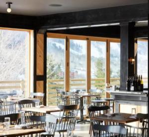 a dining room with tables and chairs and windows at SPECTACULAR CATSKILLS 4 BEDROOM VACATION OASIS- Gorgeous Hunter Mountain Views! in Hunter