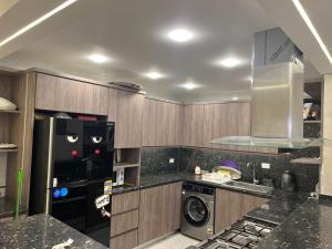 una cucina con frigorifero, lavatrice e asciugatrice di شقة فندقية فاخرة a Al Ma‘şarah