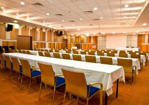 een grote vergaderzaal met een lange tafel en stoelen bij hotel ryan in New Delhi