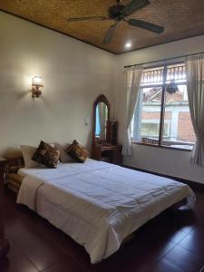 ein Schlafzimmer mit einem großen Bett in einem Zimmer in der Unterkunft Candra Asri Bungalow in Ubud