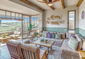 a living room with a couch and a table at Villa Salvia - Country style luxury & a captivating poolscape in Áyiai Paraskiaí