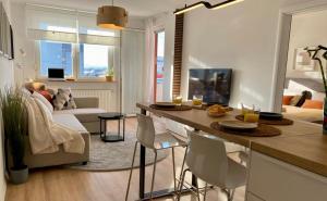 Delux apartment LA ARENA with private garage في زغرب: مطبخ وغرفة معيشة مع طاولة وكراسي