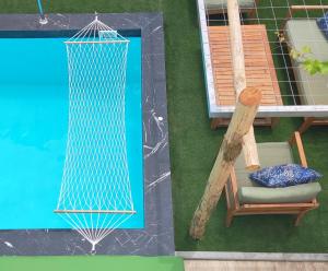 una vista aérea de una piscina con una silla y una hamaca en Villa Salvia - Country style luxury & a captivating poolscape, en Áyiai Paraskiaí