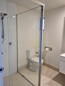 La salle de bains est pourvue de toilettes et d'une douche en verre. dans l'établissement Private Bedroom and Bathroom in a shared Apartment, à Gold Coast