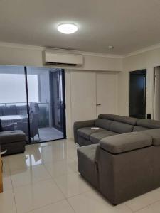 - un salon avec des canapés, un canapé et une fenêtre dans l'établissement Private Bedroom and Bathroom in a shared Apartment, à Gold Coast