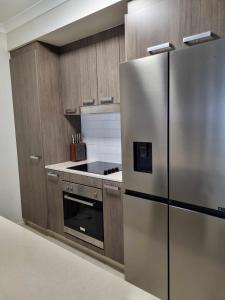 Il comprend une cuisine équipée d'un réfrigérateur en acier inoxydable. dans l'établissement Private Bedroom and Bathroom in a shared Apartment, à Gold Coast
