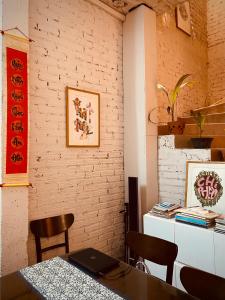 a dining room with a table and chairs and a brick wall at May’s house Nhà của Mây in Hanoi