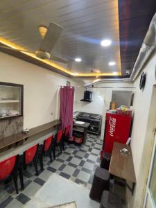 a restaurant with red chairs and a counter in a room at sun guest house 2 in Ujjain