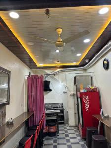 un restaurante con ventilador de techo, mesas y sillas en sun guest house 2, en Ujjain