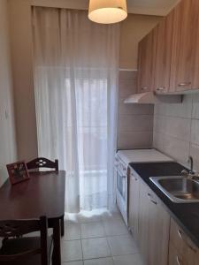 a kitchen with a table and a sink and a window at Ήσυχο και κεντρικό διαμέρισμα in Larisa +38 photos